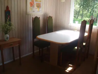 a dining room with a table and chairs and a window at Summer cottage in Nøreng