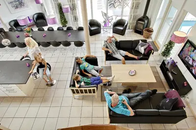 a group of people sitting in a living room at Luksus-poolhus B5 in Harboør