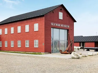 a red barn with a sign on the side of it at 6 person holiday home in Thyborøn in Thyborøn