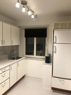 a kitchen with a white refrigerator and a window at Hel lejlighed Thisted Midtby in Thisted