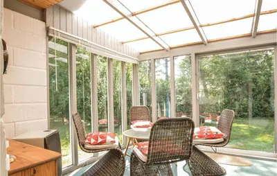 a screened in porch with chairs and a table at Three-Bedroom Holiday Home In Hjerm in Hjerm