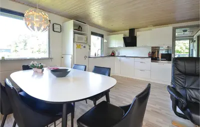 a kitchen and dining room with a table and chairs at Three-Bedroom Holiday Home In Hjerm in Hjerm