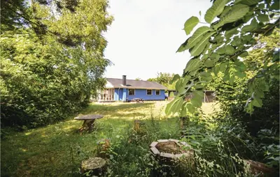 a blue house in the middle of a yard at Three-Bedroom Holiday Home In Hjerm in Hjerm