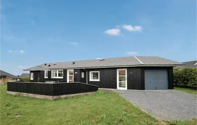 a black house with a garage in a yard at Three-Bedroom Holiday Home In Vinderup in Vinderup