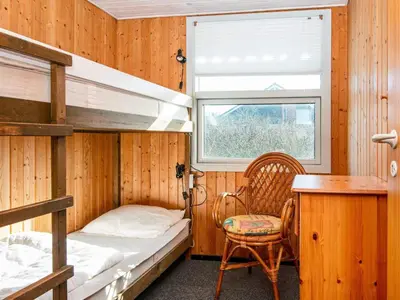 a bedroom with bunk beds and a desk and a chair at Cozy Beach House Retreat - By Traum Ferienwohnungen in Harboør