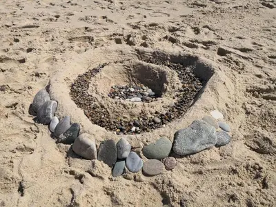 a circle of rocks in the sand on a beach at Cozy Beach House Retreat - By Traum Ferienwohnungen in Harboør