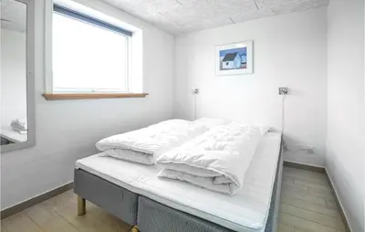 two beds in a white room with a window at Eight-Bedroom Holiday Home In Vestervig in Vestervig