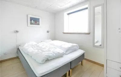 a bed in a white room with a window at Eight-Bedroom Holiday Home In Vestervig in Vestervig
