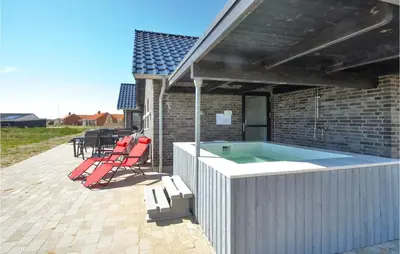 a hot tub on a patio next to a house at Eight-Bedroom Holiday Home In Vestervig in Vestervig