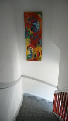 a painting hanging on a wall next to a staircase at Stor lys lejlighed på Nordmors in Sejerslev