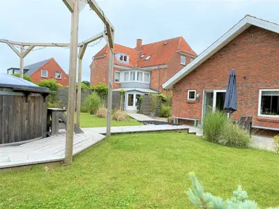 a house with a yard with a wooden deck at Stor lys lejlighed på Nordmors in Sejerslev