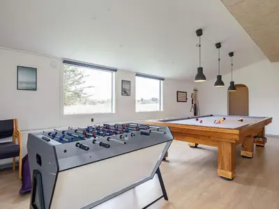 a living room with a pool table and a table at 24 person holiday home in Øster Assels in Øster Assels