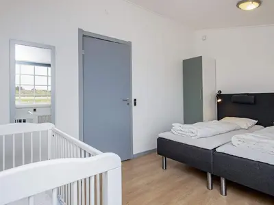 a bedroom with two beds and a stair case at 24 person holiday home in Øster Assels in Øster Assels