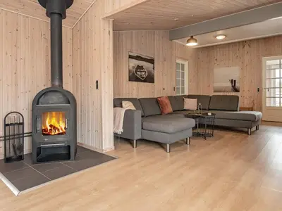 a living room with a couch and a fireplace at 24 person holiday home in Øster Assels in Øster Assels