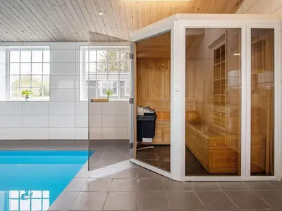 a pivot door in a room with a swimming pool at 24 person holiday home in Øster Assels in Øster Assels