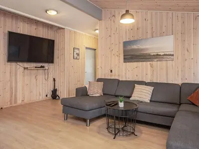 a living room with a couch and a table at 24 person holiday home in Øster Assels in Øster Assels