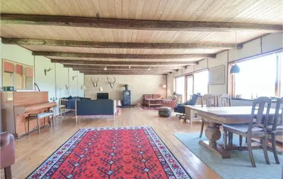 a living room with a table and a piano at Three-Bedroom Holiday Home In Frostrup in Frøstrup