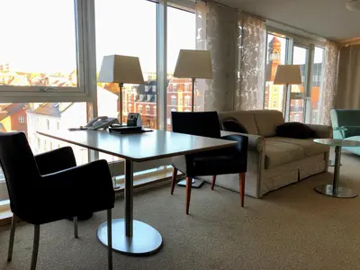 a living room with a table and chairs and a couch at Hotel Skivehus in Skive