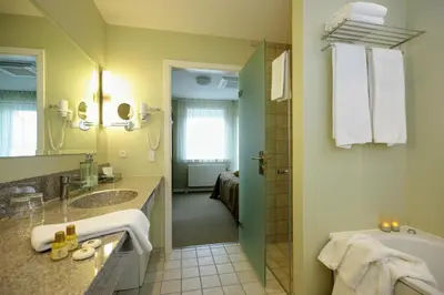 a bathroom with a tub and a sink and a shower at Hotel Skivehus in Skive
