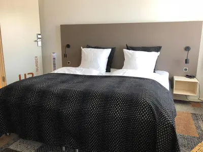 a large bed with black and white sheets and pillows at Hotel Skivehus in Skive