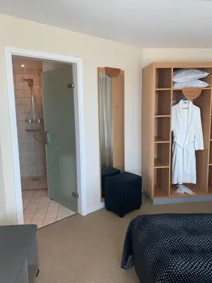 a bedroom with a bed and a bathroom with a closet at Hotel Skivehus in Skive