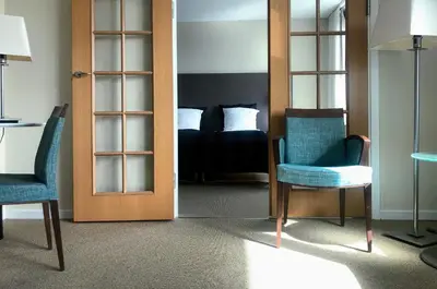 a room with a bed and two chairs and a door at Hotel Skivehus in Skive