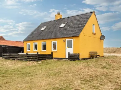 a yellow house with a black roof on a field at 6 person holiday home in Harboøre-By Traum in Harboør