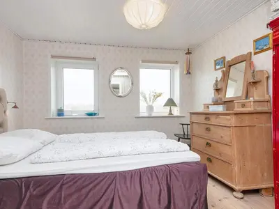a bedroom with a bed and a dresser and a mirror at 6 person holiday home in Harboøre-By Traum in Harboør