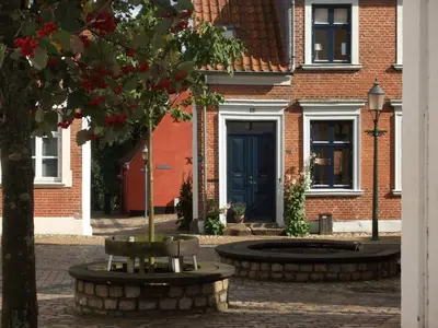 a building with a blue door and a tree at Nattely I Viborg By in Viborg