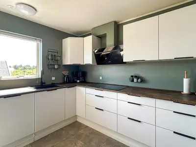 a kitchen with white cabinets and a window at 18 person holiday home in Harboøre in Harboør