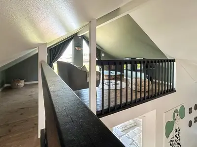 a room with a staircase with a crib and a bed at 18 person holiday home in Harboøre in Harboør