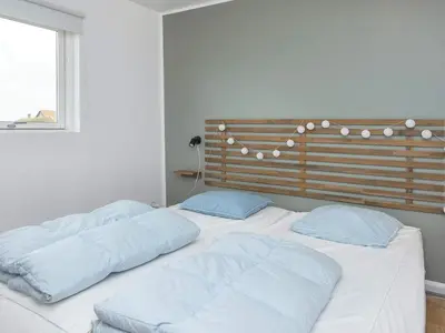 a bed with two pillows on it in a room at 18 person holiday home in Harboøre in Harboør