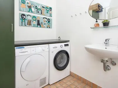 a bathroom with a washing machine and a sink at 18 person holiday home in Harboøre in Harboør