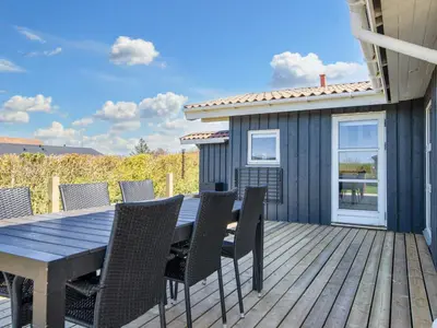 a wooden deck with a table and chairs at 6 person holiday home in Lemvig in Lemvig