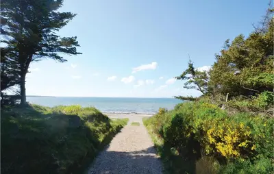 a path to the beach with trees and the ocean at Two-Bedroom Holiday Home In Spottrup in Spottrup