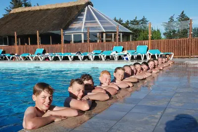 a row of boys in the water in a swimming pool at Hytteby – Hanstholm Camping – Thy Feriepark in Hanstholm