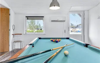 a billiard room with a pool table with bats at Five-Bedroom Holiday Home In Blokhus in Blokhus