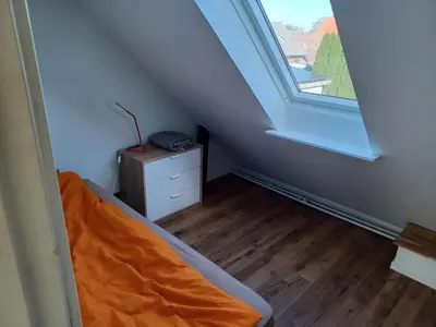 an attic room with a bed and a window at 