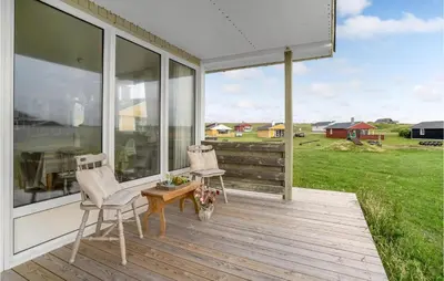 a porch with two chairs and a table and windows at Three-Bedroom Holiday Home In Lemvig in Lemvig