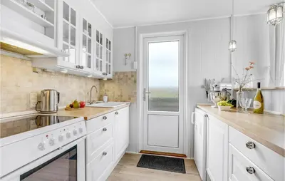 a white kitchen with white cabinets and a window at Three-Bedroom Holiday Home In Lemvig in Lemvig