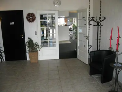 a living room with a door and a table and chairs at Motel Europa in Svenstrup