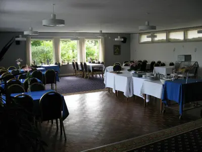 a room full of tables and chairs with blue table cloth at Motel Europa in Svenstrup