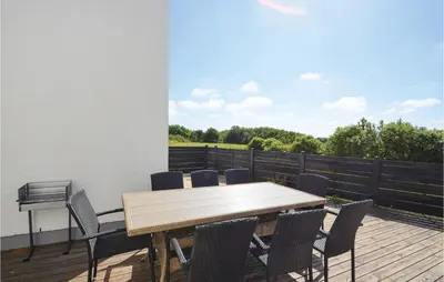 a wooden table and chairs on a deck at Three-Bedroom Holiday Home In Vestervig in Vestervig