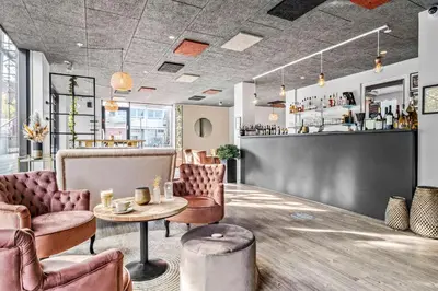 a bar with pink chairs and a table and a counter at Best Western Royal Holstebro in Holstebro