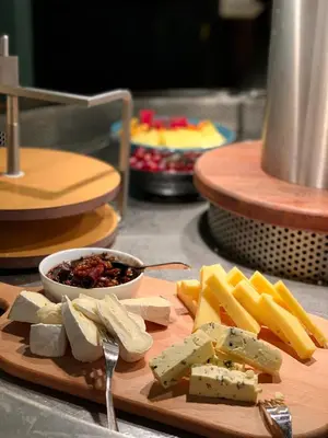 a cutting board with cheese and a bowl of salsa at Hotel Schaumburg in Holstebro