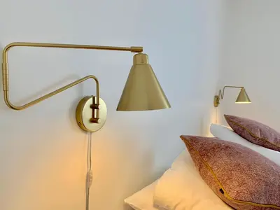 a lamp next to a bed with pillows on it at Hotel Schaumburg in Holstebro