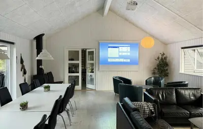 a meeting room with tables and chairs and a screen at Nice Home In Spøttrup With Sauna in Spottrup