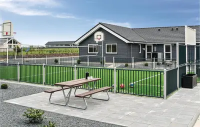 a picnic table and a bench in front of a fence at Nice Home In Spøttrup With Sauna in Spottrup