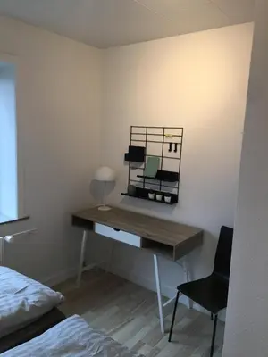 a desk in a bedroom with a mirror on the wall at Malthe Bruuns Vej 17, 1. sal in Thisted