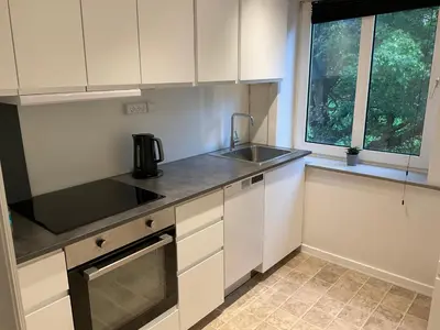 a kitchen with white cabinets and a sink and a window at Malthe Bruuns Vej 17, 1. sal in Thisted